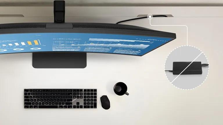 Overhead view of a desk with a curved monitor, keyboard, mouse, and coffee mug.