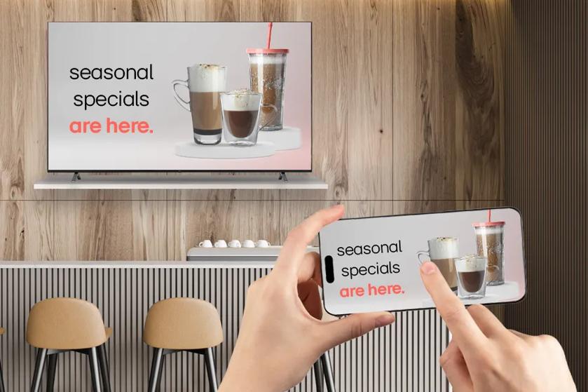 A TV and smartphone display showing an ad for "seasonal specials" with images of coffee drinks.