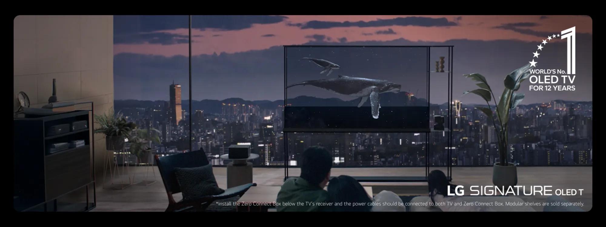 This image displays a luxurious living room setup featuring a sleek LG Transparent OLED TV against a backdrop of a city skyline at dusk. The screen showcases lifelike imagery of whales swimming, emphasizing the TV's exceptional display quality. The room includes modern furniture, such as a comfortable armchair and a side table, alongside decorative plants. A caption highlights the TV's recognition as the "World's No. 1 OLED TV for 12 Years," reinforcing its premium status. The overall ambiance exudes sophistication, blending cutting-edge technology with a relaxing atmosphere.