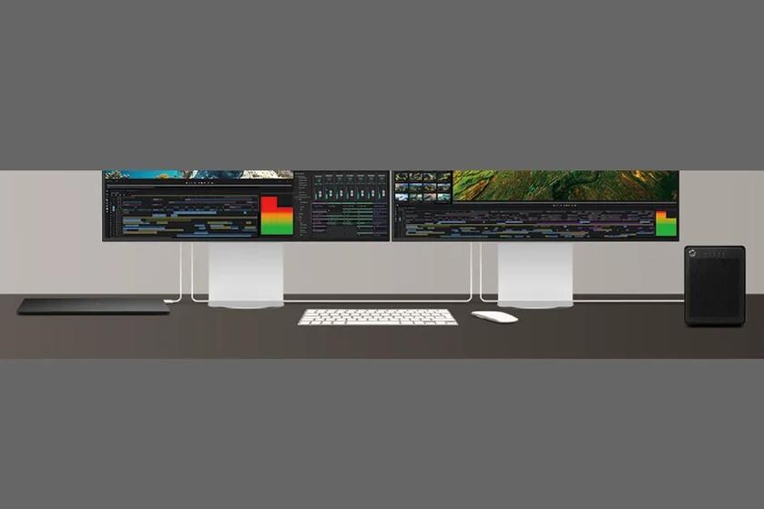 Dual-monitor video-editing workstation with a white keyboard, mouse, cables, and black desktop computer tower.
