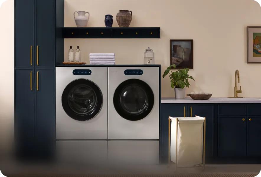 LG SIGNATURE Seamless Collection front-load washer and dryer pair in brushed steel with tinted glass doors, installed side by side in modern laundry room.