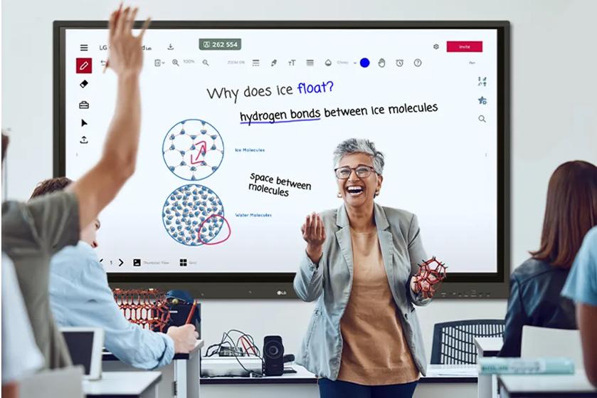 A high school teacher in a classroom with an LG CreateBoard behind her.