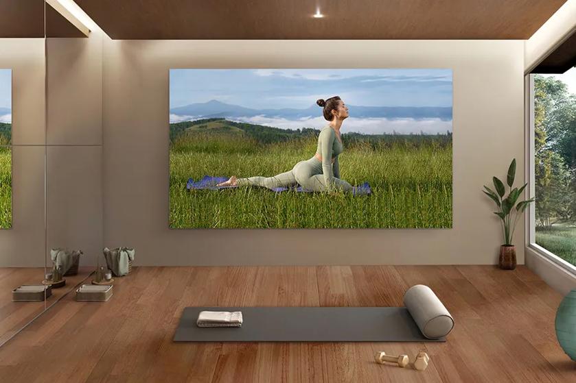 A modern room with fitness equipment and a large photo of a woman doing yoga in a grassy field.