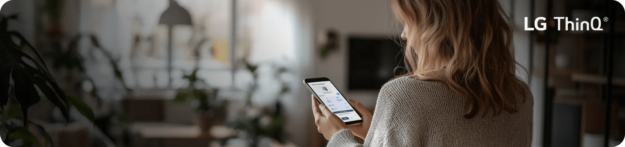 A woman uses the ThinQ® app on her smartphone.