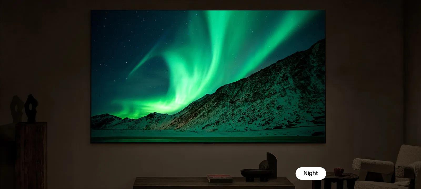 A TV screen showing the northern lights over mountains, split down the middle to compare brightness and contrast in day and night modes.