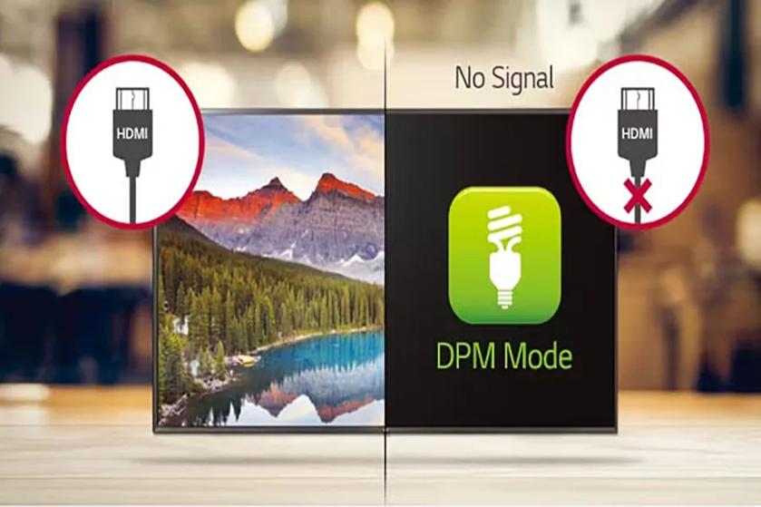 The image shows a digital display split into two sections. The left side features a vibrant image of a natural landscape with a lake, surrounded by dense green trees, and mountains in the background under a colorful sky. The foreground includes a wooden table surface, slightly blurred. The right side of the split screen is blank except for a green icon featuring a white CFL bulb, symbolizing "DPM Mode," on a black background. Above the icon, the words "No Signal" are displayed. On each side of the display, circular icons show an HDMI plug; the left icon is normal, while the right icon has a red "X" indicating no connection.