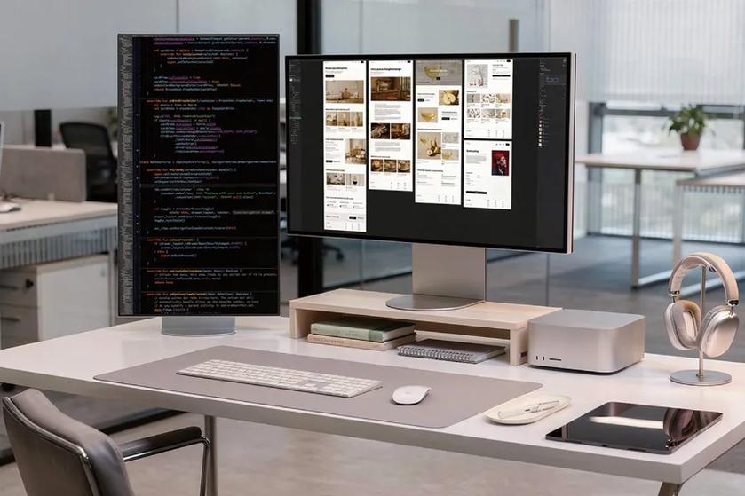 Modern office workstation with two monitors displaying code and interface designs, alongside a keyboard, computer, tablet, and headphones.