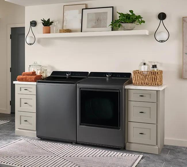 Dark gray top-load washer and front-dryer in a modern laundry room.