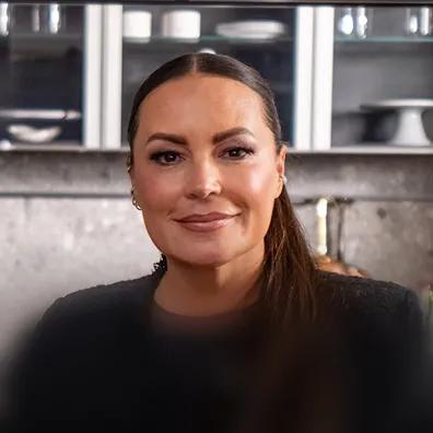 Photo of Angie Martinez with a cabinet in the background.
