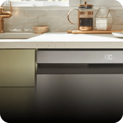 An LG dishwasher sits flush underneath the countertop in a modern, brightly lit kitchen.