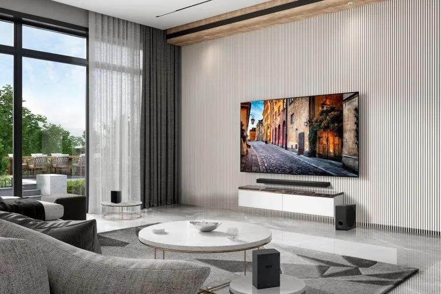 77-Inch LG 4K OLED TV OLED77B6GUA wall mounted in modern living room with surround sound speakers