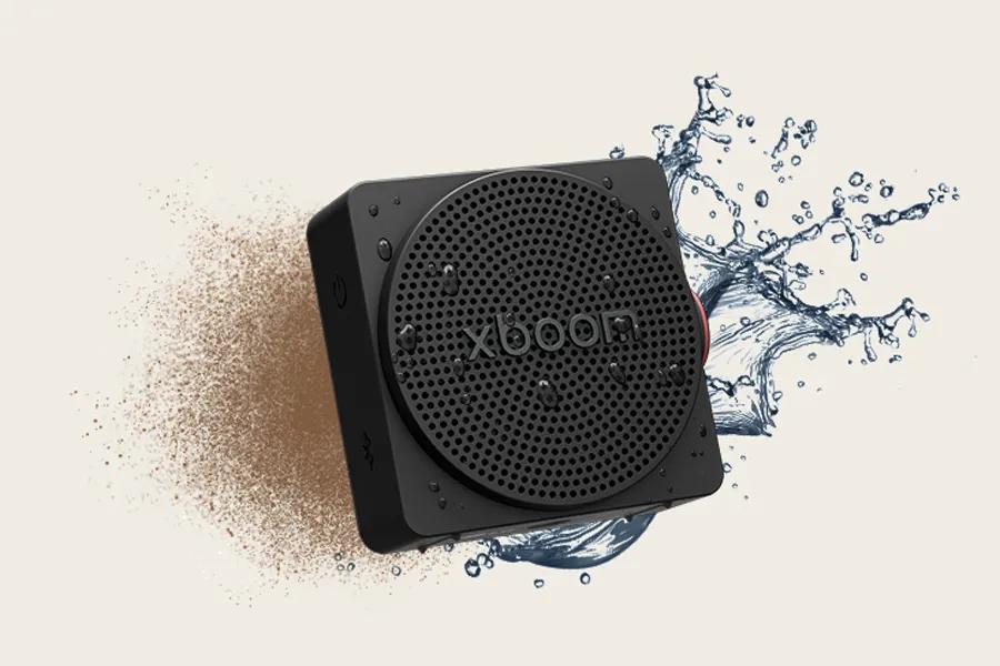 MINI_ANOALBK LG xboom portable speaker with water splash and dust particles showing waterproof durability feature