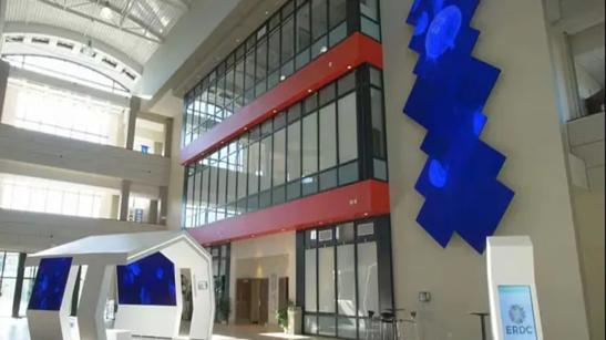 Interior of a government lobby, with bold LG signage displaying abstract art.