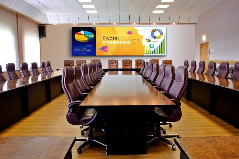 Modern conference room with a U-shaped table and digital screen displaying a presentation.