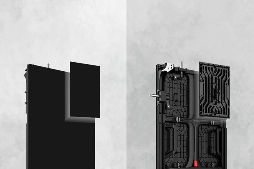 The image features a side-by-side comparison of two rectangular panels against a light, textured background. The left panel is a solid matte black rectangle with a smaller black rectangle tilted slightly, suggesting it may be a cover or part of a modular system. The right panel presents the back view of a similar structure with intricate geometric patterns and several visible components, including metallic rods and connectors, indicating its functional complexity.