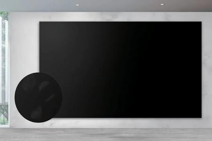 Large black canvas on a light gray wall in a modern interior with natural light.
