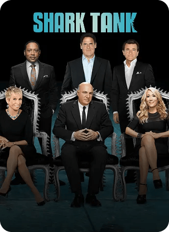 Shark Tank photo featuring six investor-hosts posed in black suits against a black background.
