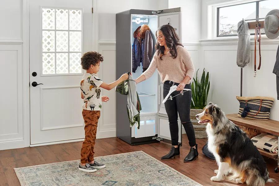 Image of family taking clothes sanitized with TrueSteam out of LG Styler with TrueSteam logo