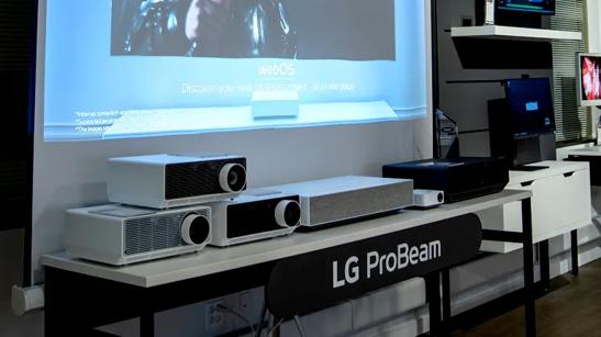 LG ProBeam projectors on display, with a projector showing a glimpse of a projected video near the top of the image.