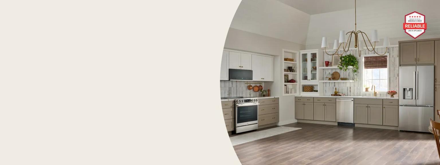 Modern kitchen with beige lower cabinets, white upper cabinets, stainless steel appliances, a central chandelier, and wood-look flooring. In the top right corner, a red and white badge reads: "America's Most Reliable Line of Appliances."