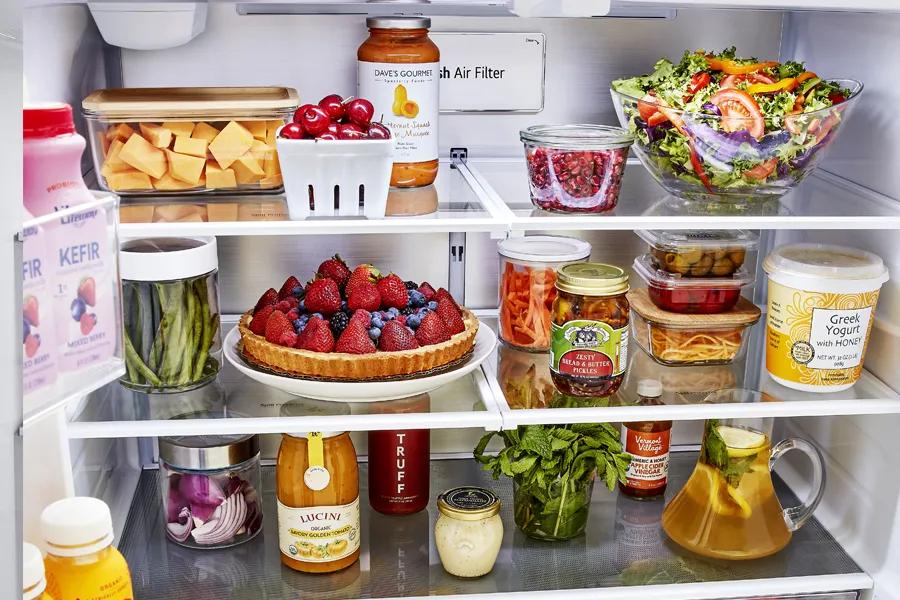LG LRFLC2726S French Door Refrigerator interior with fresh air filter and shelves stocked with fresh produce and food