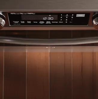 A image shows the rear heating element of an LG range oven roasting a chicken and causing baking cookies to rise.