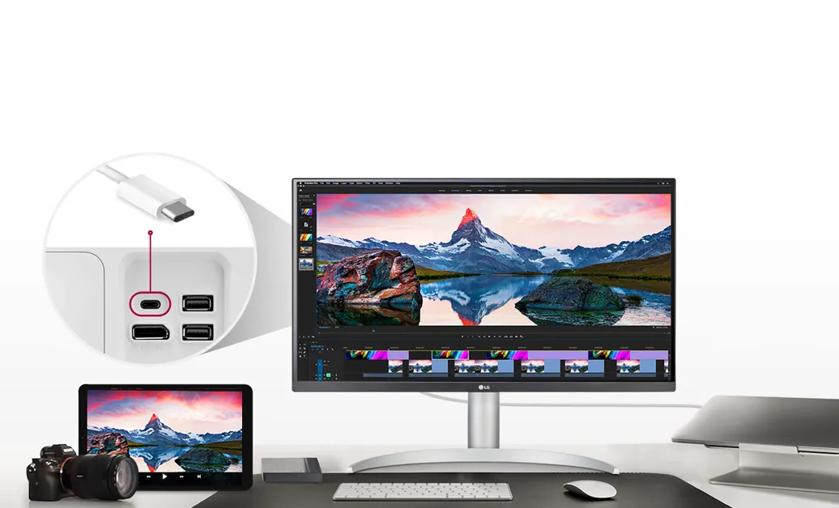 Workspace with an ultrawide monitor displaying a mountain scene, a zoomed-in view of USB-C port, and a tablet on a desk with a camera.