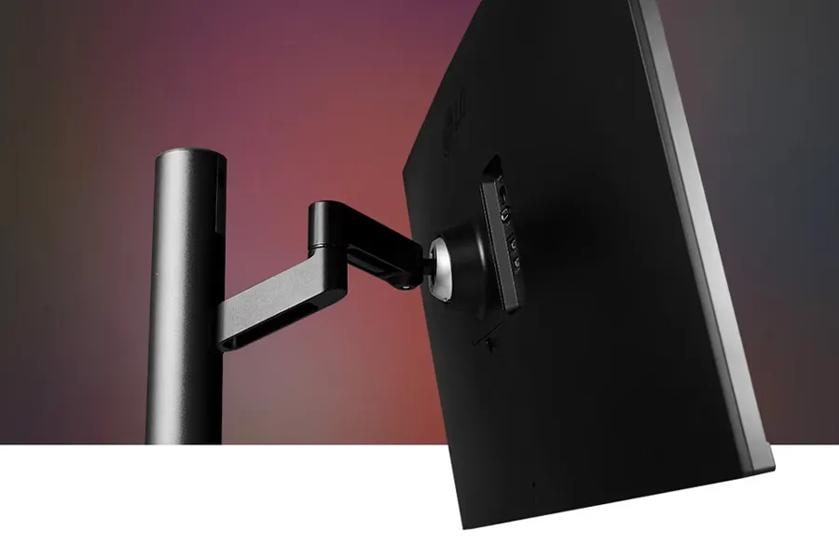 Back view of a monitor on an adjustable black arm with a gradient background.