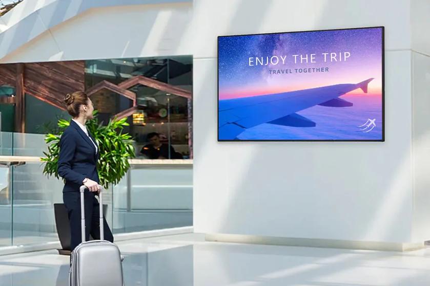 UHD Digital Signage woman looking at signage traveling hero