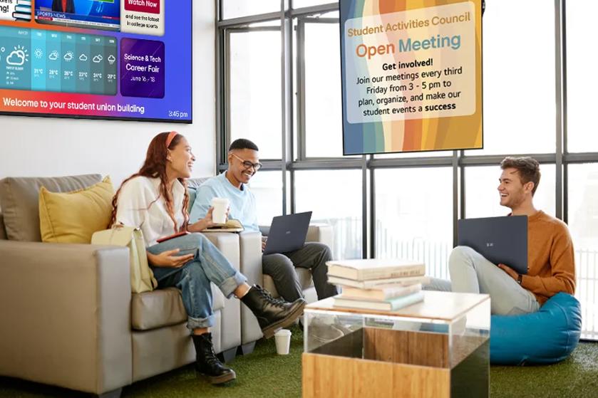 University students socialize in a student commons building, using LG gram laptops and surrounded by various LG signage to keep up to date on campus events.
