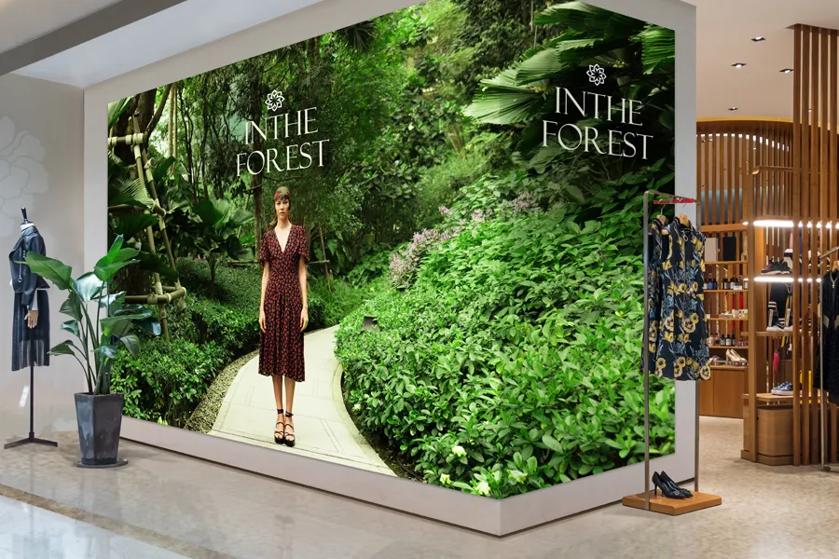 Large advertisement of a woman in a forest; text reads "IN THE FOREST."