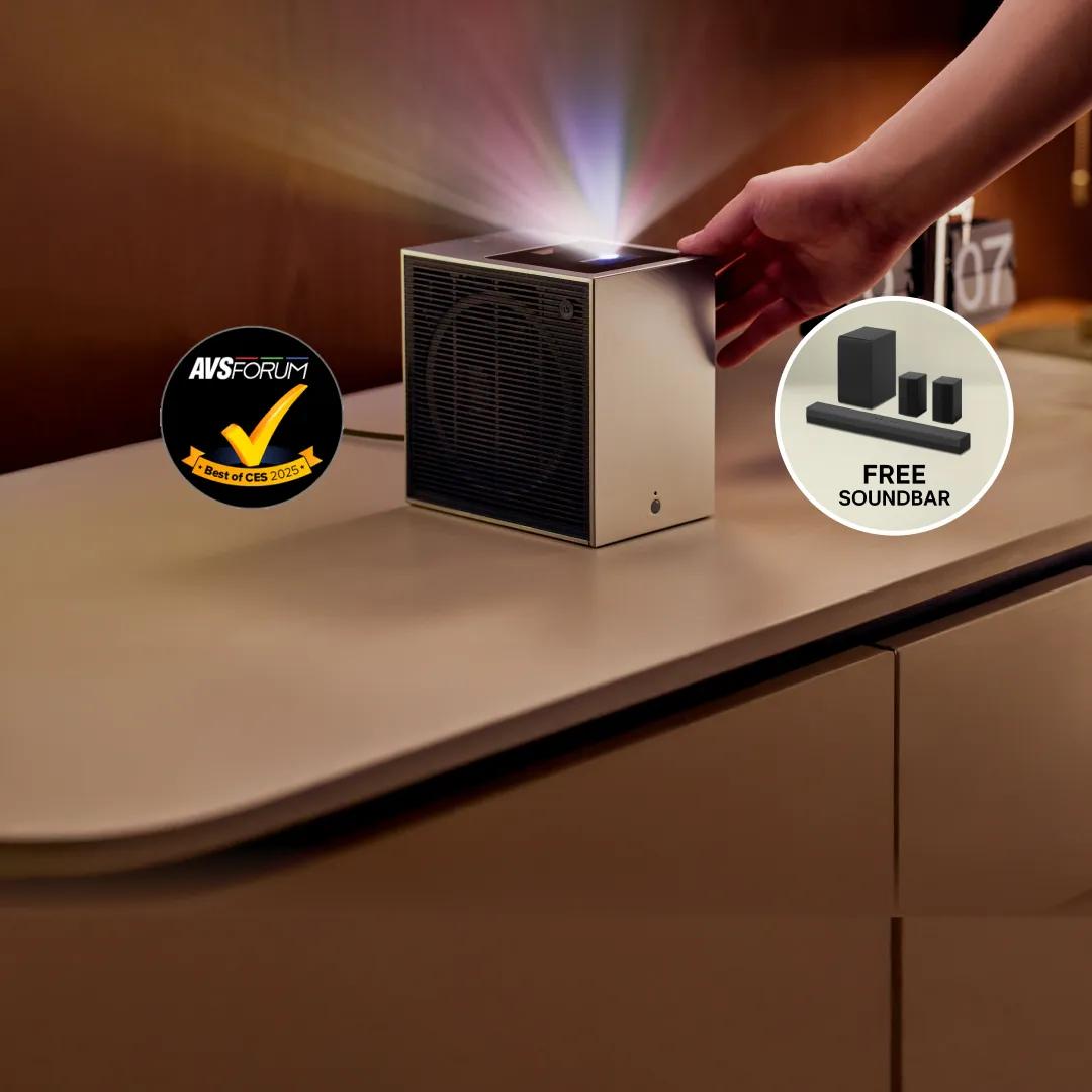 Closeup of an LG CineBeam S projector. Pop-up reads “Free soundbar home theater soundbar with  Dolby® Rear Speakers. “AVS Forum Best of CES 2025” badge below.
