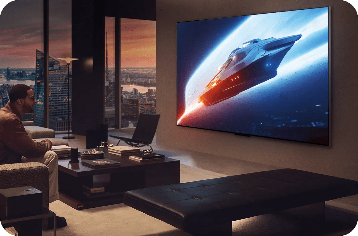 Man watching a sci-fi spaceship scene on a large LG TV in a modern city apartment at sunset.