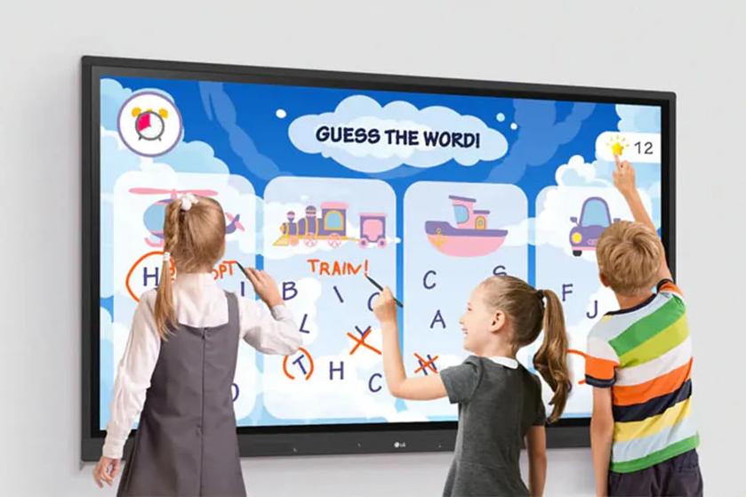 School children interacting with LG CreateBoard, using the touch screen to solve an educational word game.