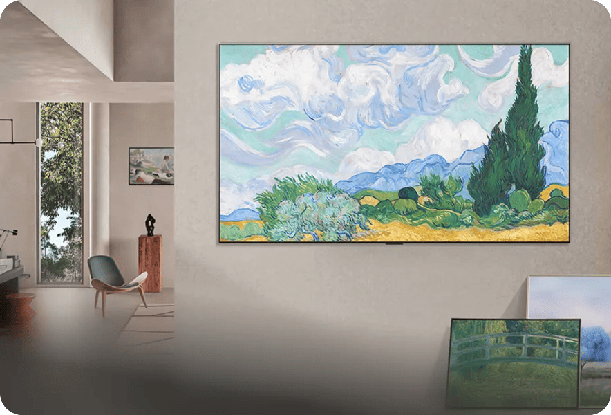 LG TV wall-mounted in a modern living room displaying a classic landscape painting, with additional framed artwork and a smaller display visible nearby.