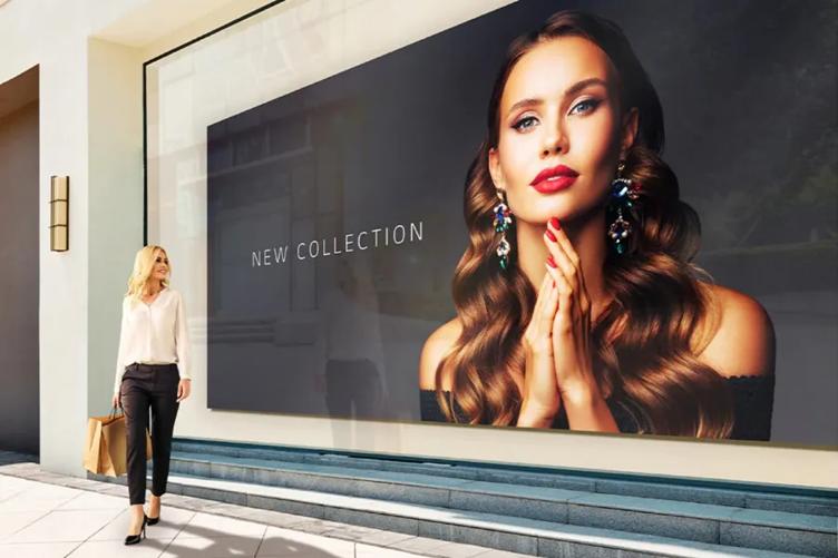 A woman stops to admire the large LG DVLED display, which advertises a new fashion collection. 