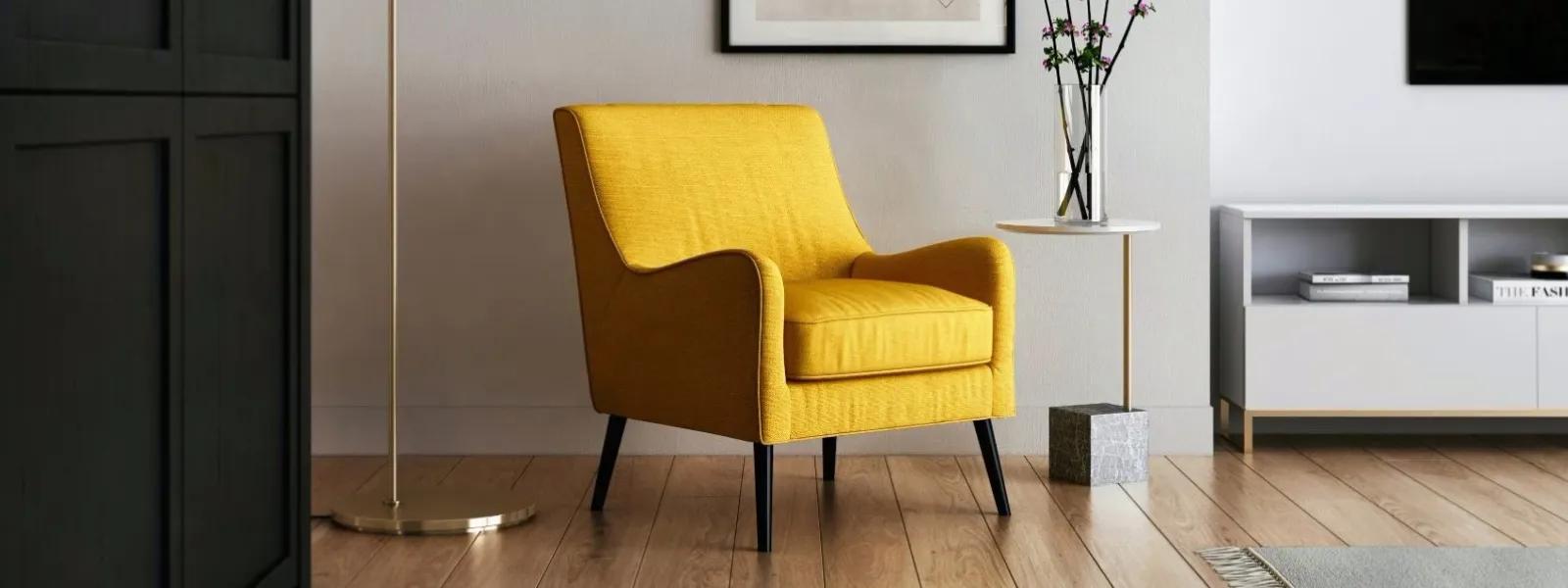 Living room space with yellow accent couch, modern side table with flowers in a vase, gold lamp pole, and mounted TV. 