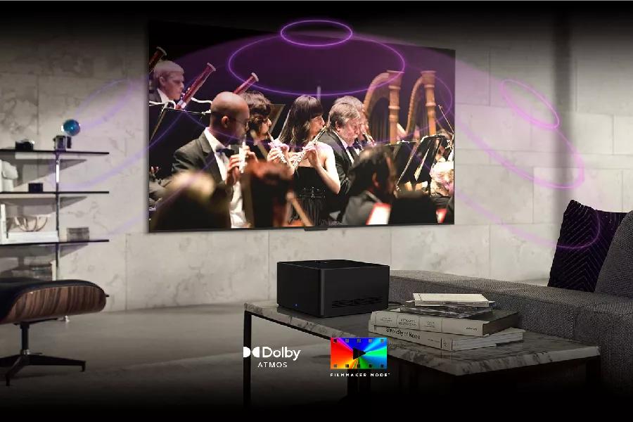 A symphony plays on-screen with sound waves reverberating from the TV. Dolby Atmos logo. FILMMAKER MODE logo.