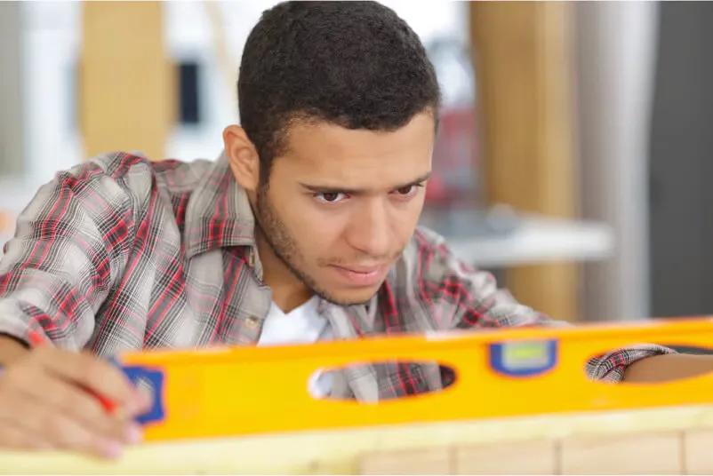 construction worker using a yellow leveler 