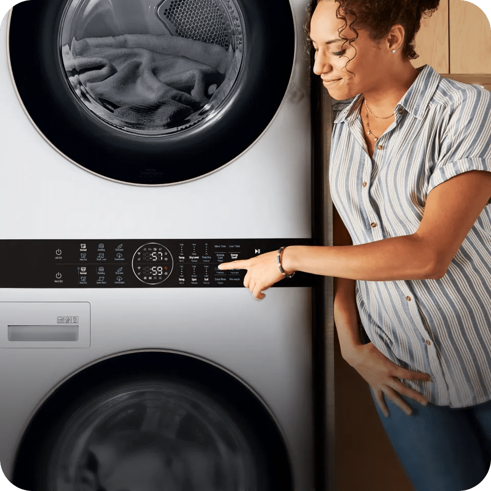 A woman presses a button on the Center Control® Panel of her LG WashTower™.