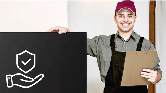 A workman holds a clipboard with one hand and smiles at the camera. His other hand is resting on a large LG display. The display's screen is dark with an icon of a hand holding a shield with a checkmark on it.