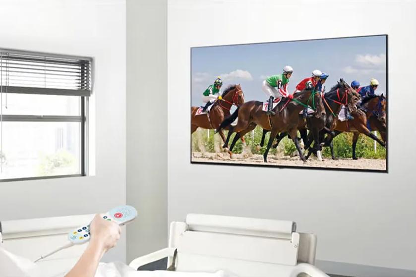 Patient in a hospital room watching a horse race on a wall-mounted LG TV.