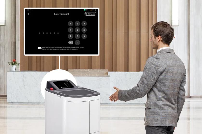 CLOi ServeBot and a man in a suit stand in an upscale hotel lobby. The man is reaching for her display, presumably to enter a password. A white circle behind CLOi is connected by a line to a pop-out closeup of her display, showing the password input screen.