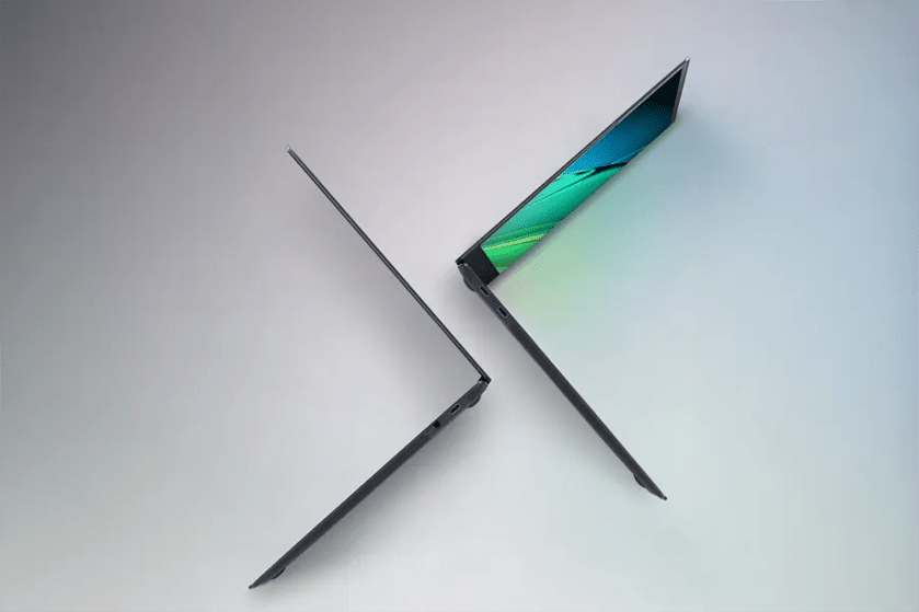 Two open laptops in a symmetrical arrangement with vibrant screens against a gradient background.