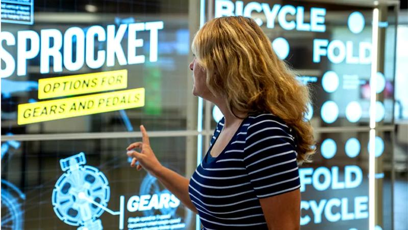 A guest smiling as she leans in to examine the LG Transparent OLED signage on display at the Chicago BIC.