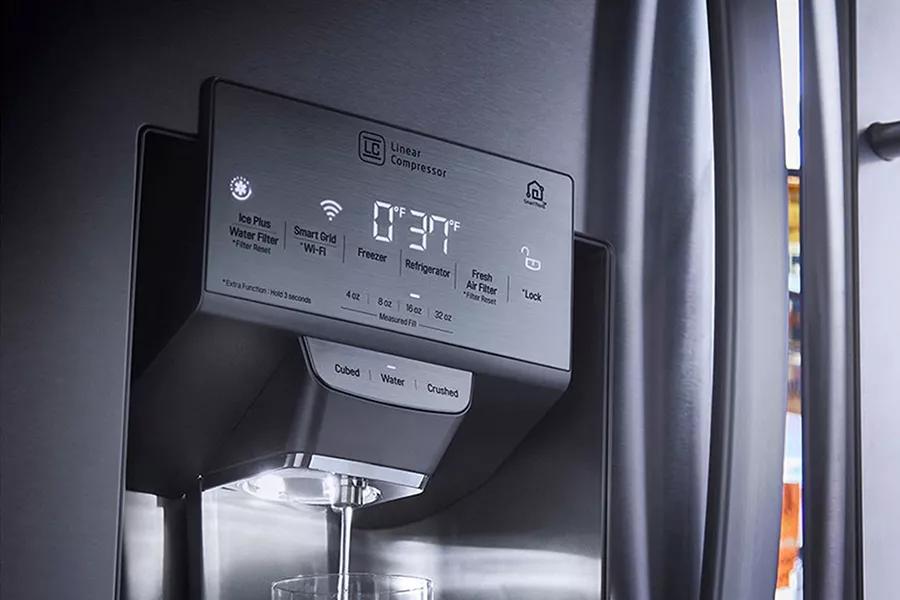 Refrigerator showcasing Ice and Water Dispenser filling a glass of water