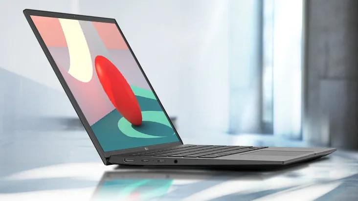 An LG gram laptop displaying an abstract design on the screen sits on a reflective surface in a bright room.