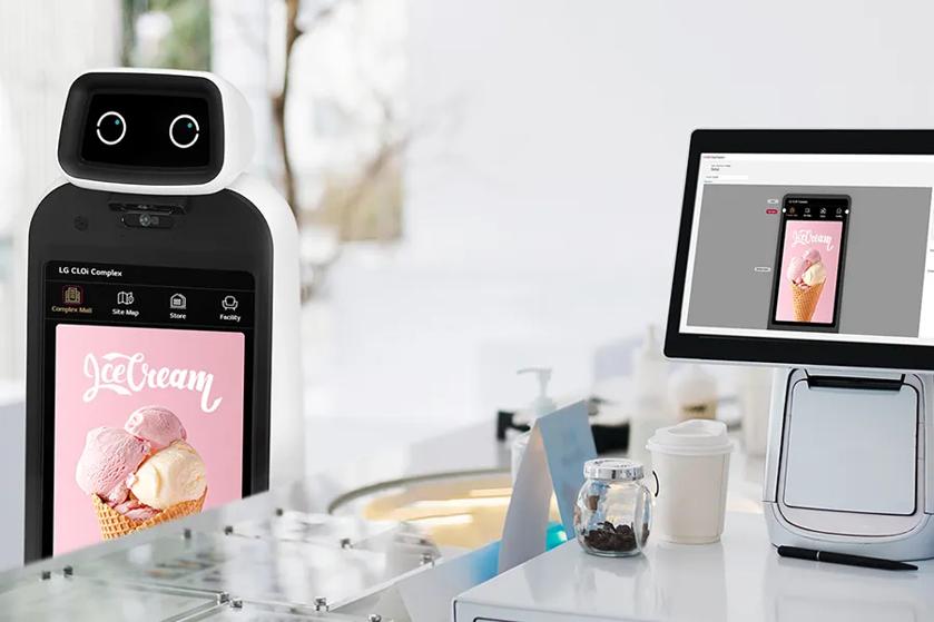 CLOi stands near a counter with a small monitor. The monitor displays a bright ad graphic for the small business, which is also on CLOi's display.