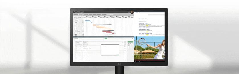 A workspace with an LG UltraWide Monitor displaying graphs and tasks, along with a keyboard, mouse, and stationery.