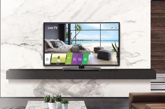 Hotel room with an LG TV displaying a vibrant background and LG menu.
